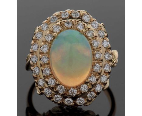 18ct opal and diamond ring, the central oval opal cabochon, approx. 13.1 x 9.8 x 6.1mm, surrounded by two rows of small round