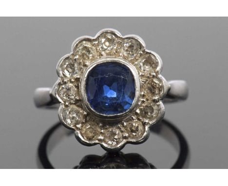 Sapphire and diamond cluster ring, the cushion shaped faceted sapphire is 7x7x4mm approx, bezel set within an old cut diamond