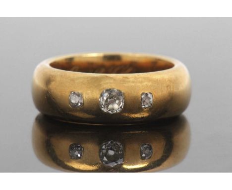 Antique three stone diamond ring featuring three graduated old cut diamonds in a plain polished wide band, engraved and dated