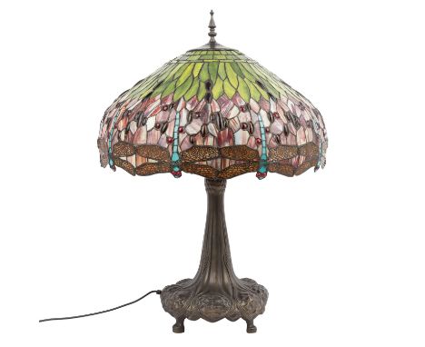 Tischlampe im Stil von TIFFANY'S, 20. Jhd. Brünierter Metallfuß mit Blattdekor, darüber ein glockenförmiger Glaslampenschirm 