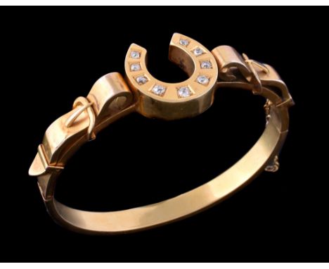  Equine interest, a Victorian diamond set gold hinged bangle,   circa 1880, the  central horseshoe shaped panel set with grad