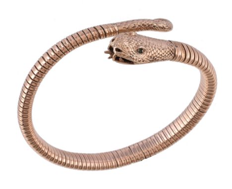  A 9 carat gold serpent bangle,   the coiled snake with circular cut emeralds to the eyes, stamped 375 with full London hallm