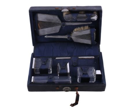 Ω A cased silver mounted eight piece travelling dressing table set by Collett &amp; Anderson, London 1934, comprising: three 