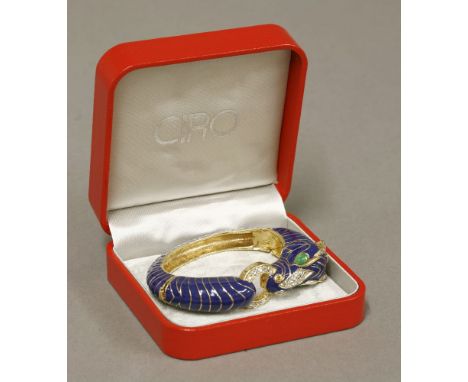 A gold-plated paste and enamel zebra bangle,by CINER, a hinged bangle with the head of a zebra set with cabochon green paste 