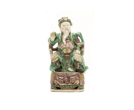 A large Chinese famille verte on biscuit figure of GuandiQing dynasty, Kangxi periodThe god of war modelled seated on a tiger
