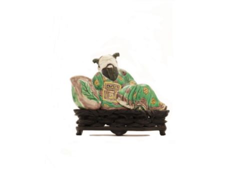 A Chinese famille verte on biscuit figural water potQing dynasty, Kangxi periodModelled as a man wearing a floral robe, resti
