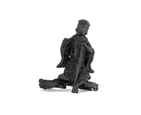 A Chinese bronze statue of Li TieguaiMing dynastyThe detachable figure sitting on stylised rock, with left hand holding a wal