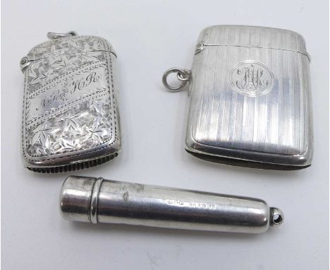 A George V silver vesta of hinged rectangular form having engine turned decoration and monogrammed cartouche with gilt washed