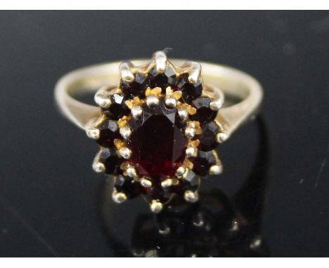 A silver-gilt garnet set flower head cluster ring, size L