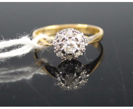 An 18ct gold diamond flower head cluster ring, the centre claw set round cut weighing approx 0.15 carats, within a further su