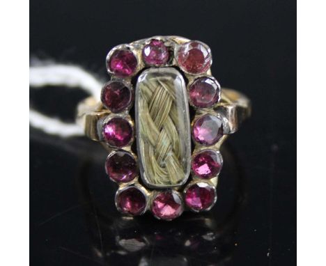 A vintage 9ct gold paste set mourning ring, centre set under crystal with a plait of hair, setting dimensions 18 x 14mm, size