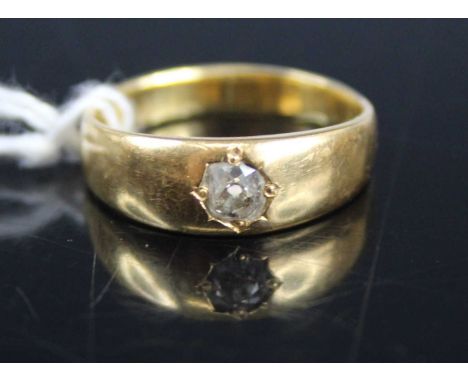 A yellow metal diamond solitaire ring, 'gypsy' set with a round cut diamond weighing approx 0.2 carats, size K/L, unmarked bu