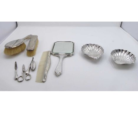 A George V silver butter dish, of typical shell shape; together with another and various silver-backed dressing table items t