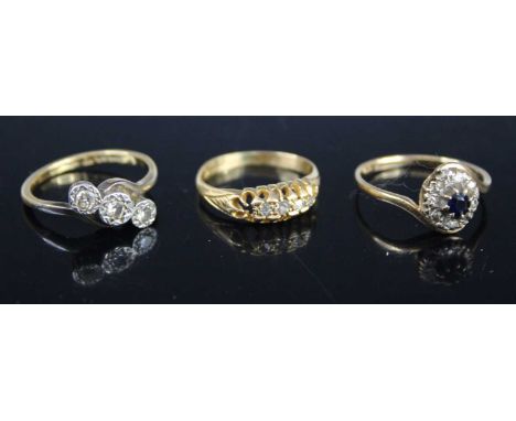 An 18ct gold and platinum diamond crossover ring, arranged as three small illusion set round cuts, size M; together with an 1