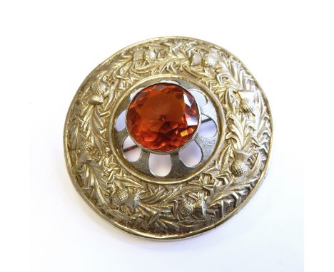 Scottish silver coloured metal and paste sash brooch, circular, thistle embossed and set centre orange coloured paste 