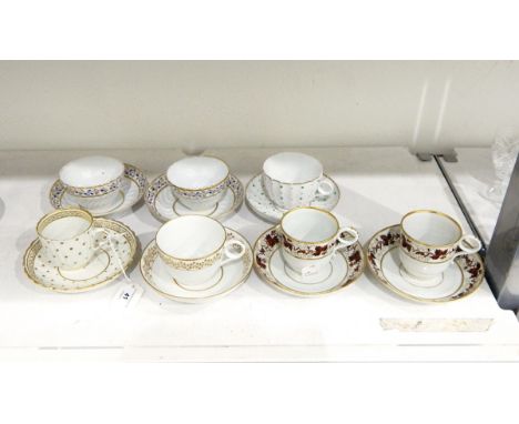 Pair of early 19th century teacups and saucers decorated with a band of rust-coloured fruiting vine with gilt borders, a pair