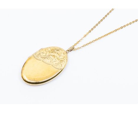 A 9ct gold oval locket with engraved decoration, size approx. 45 x 28mm, on an unmarked yellow metal &nbsp;fine link chain, t