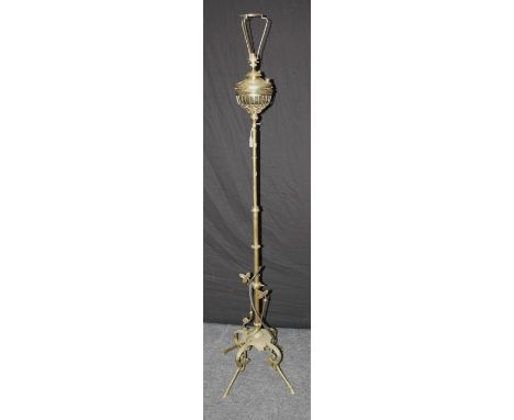 An early 20th century brass paraffin standard lamp, converted for electricity, on four leaf cast supports and hoof feet, 178c
