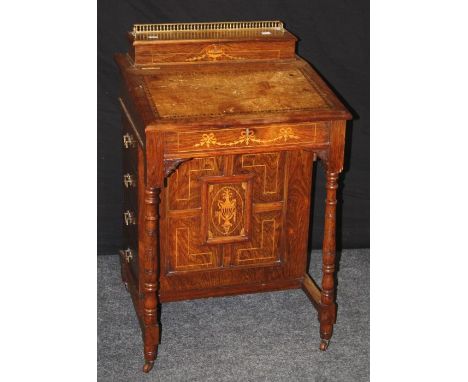 An Edwardian rosewood, inlaid and strung Davenport, the brass gallery rail over rising stationery compartment and tooled scri