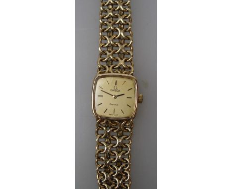 A lady's 9ct gold Omega wristwatch, the 1.5cm champagne dial with baton numerals, on a chain link bracelet. Gross weight 31gm