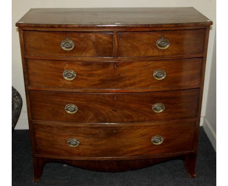 An early 19th century mahogany bow front chest of two short and three long graduated drawers with brass drop handles, on brac