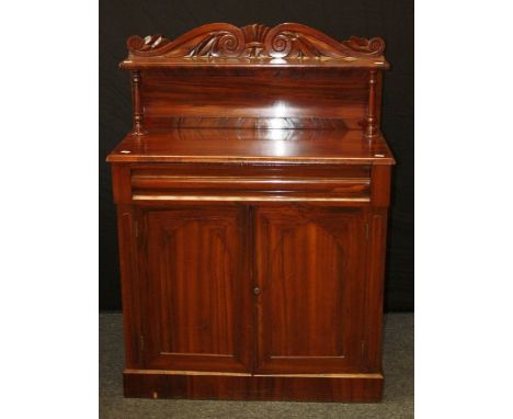 A Victorian rosewood chiffonier, the scroll carved panelled upstand over ogee frieze drawer and a pair of navette panel cupbo