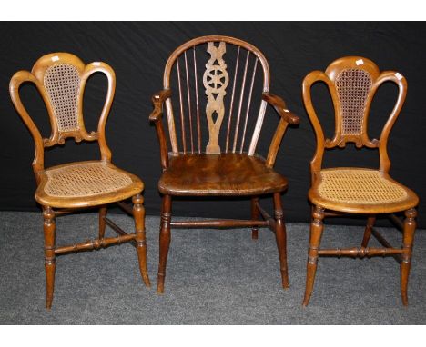 A pair of Edwardian walnut 'crown back' cane upholstered bedroom chairs and a single 19th century elm seated wheel and stick 