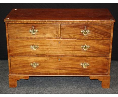 A 19th century mahogany low chest, having two short and two long drawers with later brass batswing drop handles, on bracket f