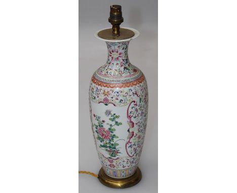 A 19th century Chinese famille rose vase of slender baluster form, decorated with winged insect reserves of peonies on a busy