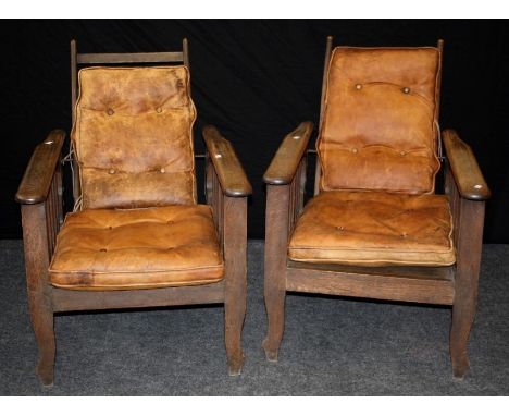 A pair of early 20th century oak plantation type reclining armchairs each with metal rod adjustable ladder back, elongated ar