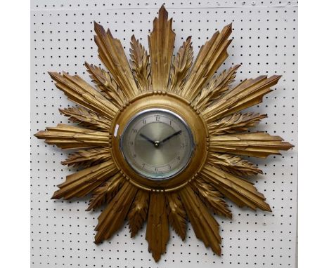 An early 20th century sunburst wall clock, the moulded giltwood case enclosing a silvered Arabic dial, with later quartz move
