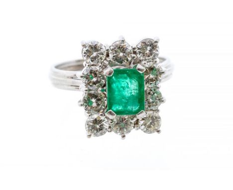 A GRAFF&nbsp;emerald and diamond 18ct gold cluster ring, comprising an emerald cut stone claw set to the centre, &nbsp;size a