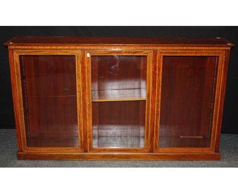 An Edwardian mahogany satinwood crossbanded and strung library bookcase, the rectangular top over three glazed doors, enclosi