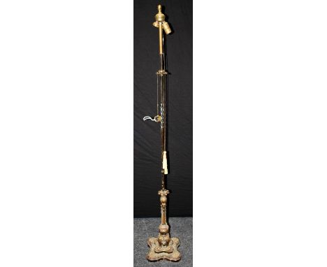 An early 20th century wrought iron, gilt metal mounted and brass standard lamp, on scallop decorated quatrefoil base