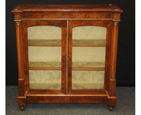 A Victorian burr walnut, gilt metal mounted , boxwood inlaid and strung bookcase, the inverted breakfront top over a pair of 