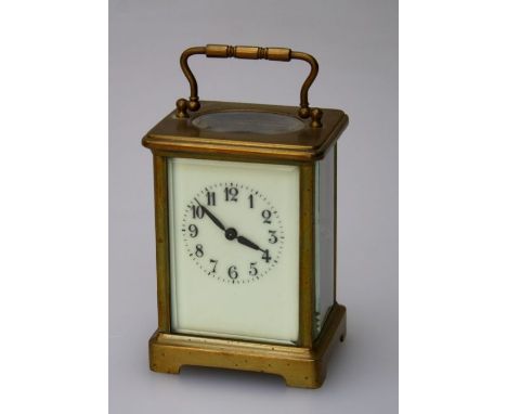 An early 20th century French carriage clock, the brass five glass case enclosing an eight day movement faced by ivorine Arabi
