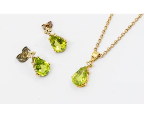 A peridot and diamond 9ct gold pendant and earring set, comprising a pendant with a claw set pear shaped peridot with a singl