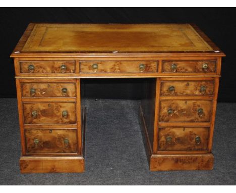 A good reproduction burr yew twin pedestal writing desk, the rectangular scriber set top over an arrangement of nine drawers,