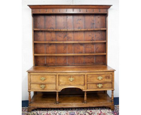 An 18th/19th century welsh oak dresser, in two sections with upper open rack with iron hooks, the base with five drawers, pot