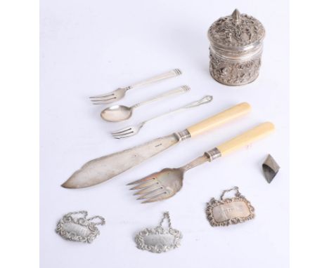 White metal embossed foreign jar and cover, three silver decanter labels, three silver spoon and fork and silver bladed serve