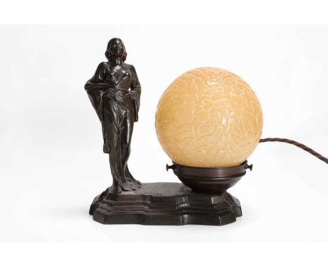 An American Art Deco Odeon style spelter lamp, c.1930, the textured globular shade flanked to the left by a sculpture purport