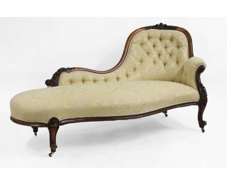 A Victorian carved walnut settee, c.1860, with Prince of Wales feather decoration, upholstered in buttoned floral yellow fabr