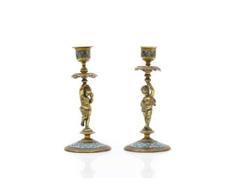 A pair of ormolu and champleve figural candlesticks 19th century, French, in the form of putti holding sconces, to enamelled 