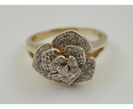 A 9CT GOLD DIAMOND ROSE CLUSTER HEADED DRESS RING, having central diamond surrounded by three tiers of diamonds mounted in go