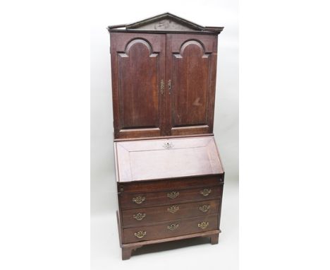 A GEORGE III OAK BUREAU CABINET, the top section fitted twin panelled doors, the base with fallfront over three drawers with 
