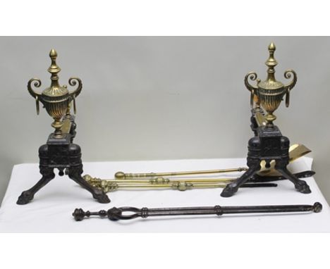 A PAIR OF VICTORIAN CAST IRON FIRE DOGS, having brass urn mounts, 47cm high, together with four brass and iron FIRE TOOLS, in