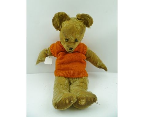 AN EARLY TO MID 20TH WORN MOHAIR TEDDY BEAR, having articulated limbs and boot button eyes, wearing an orange hand knitted ta