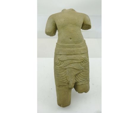 A 12TH CENTURY CARVED STONE TORSO FROM ANKGOR WAT, the temple complex in Cambodia, originally constructed as a Hindu temple o