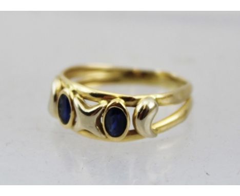 A DRESS RING SET WITH TWO SAPPHIRES, considered 18ct gold, size L 1/2 