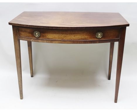 A 19TH CENTURY MAHOGANY BOW FRONTED SIDE TABLE, having single frieze drawer with brass ring handles, raised on squared taperi